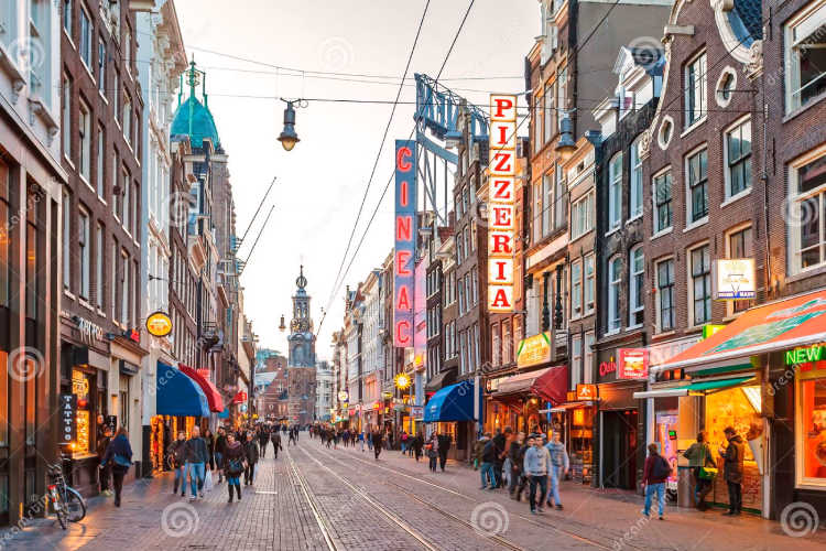An example of a street: a roughly 8-12 metre-wide pedestrianised street, with tram lines going down the centre, a variety of covered shops located at street-level and residential homes above them rising to 4 stories in total, which is roughly the same height as the width of the street