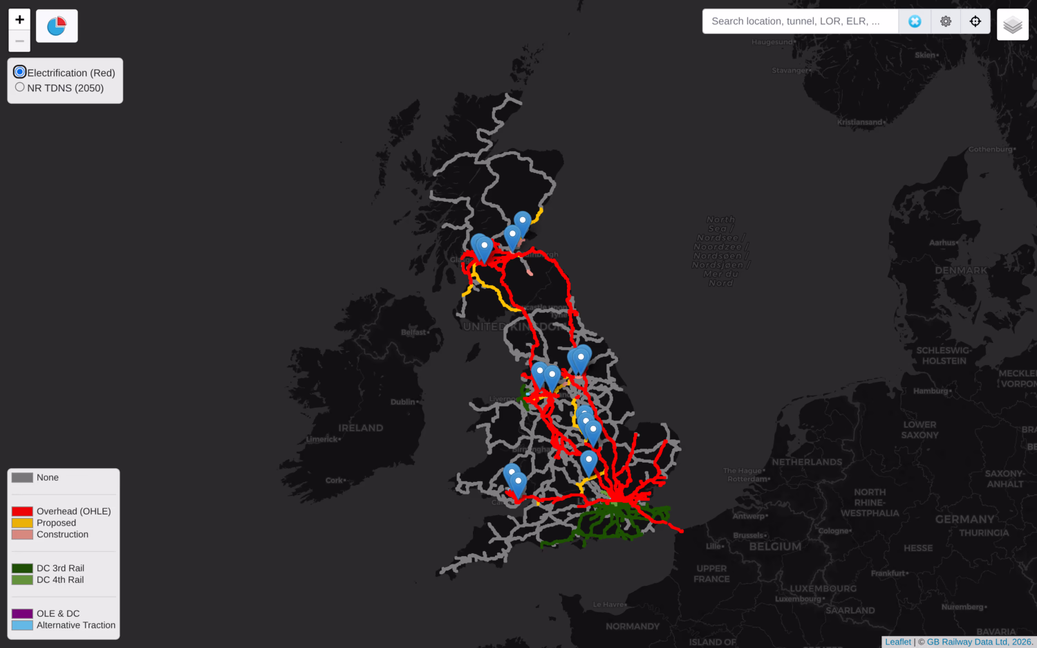 Screenshot of ElectrificationMap showing the current GB network, which is mostly red (overhead AC), except for green (third rail DC) in the South East, and a few areas of orange (proposed overhead). There's blue markers to show ongoing and recent electrification projects.